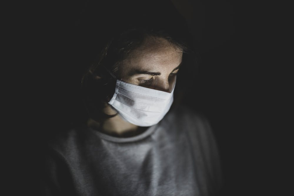 Person wearing a medical mask with dark background